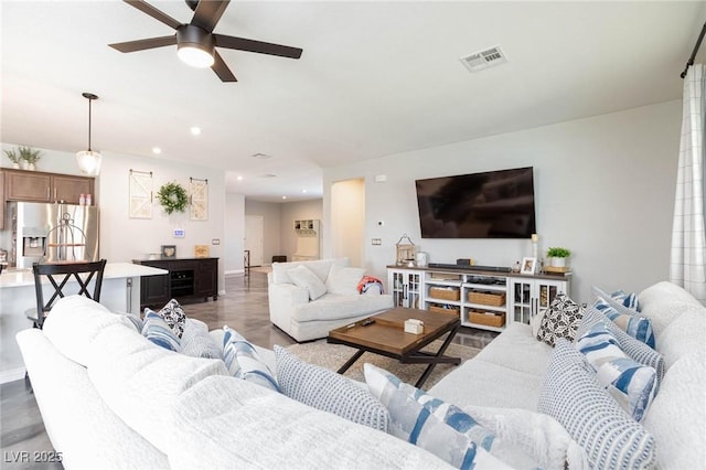 living room featuring ceiling fan and dark hardwood / wood-style flooring