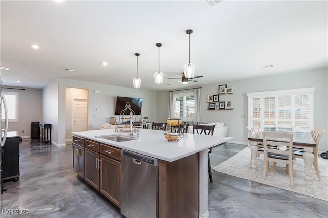 kitchen featuring dishwasher, a healthy amount of sunlight, a center island with sink, and a breakfast bar