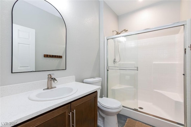 bathroom featuring walk in shower, vanity, and toilet