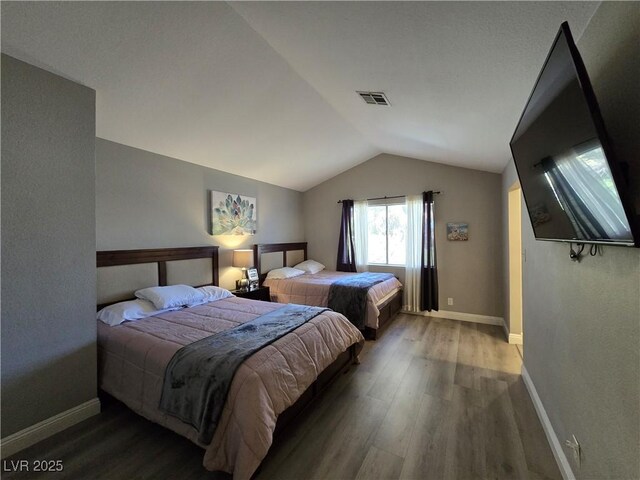 bedroom featuring vaulted ceiling and hardwood / wood-style flooring