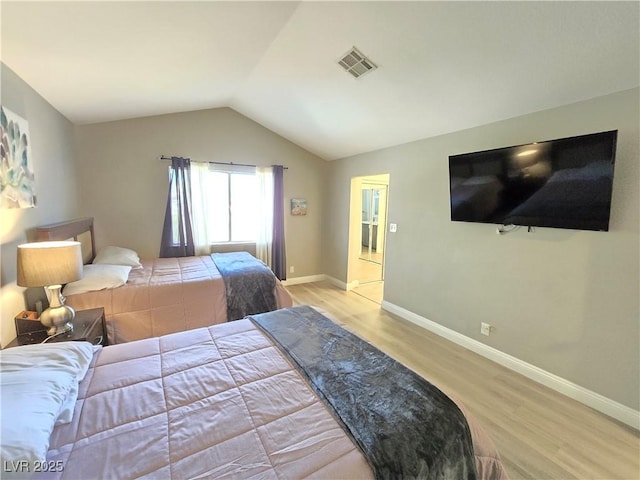 bedroom featuring vaulted ceiling and light hardwood / wood-style flooring