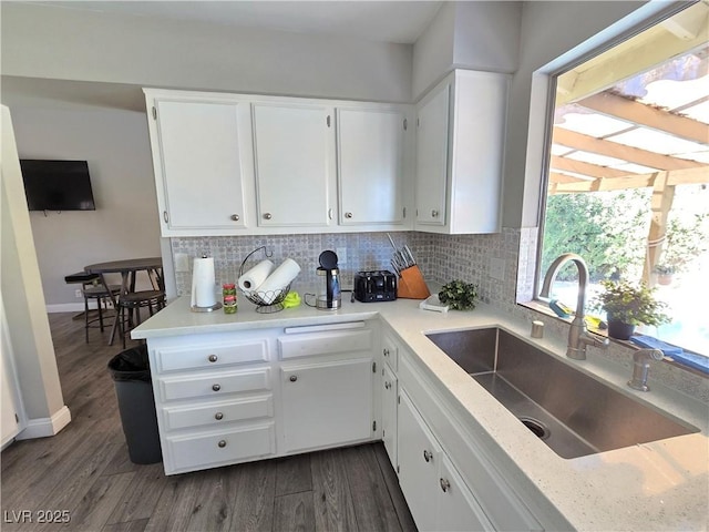 kitchen with decorative backsplash, dark hardwood / wood-style flooring, sink, and white cabinetry