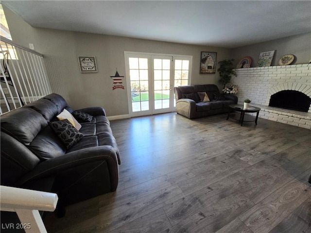 living room with a brick fireplace and hardwood / wood-style flooring