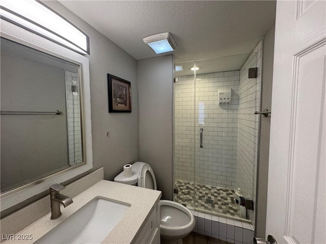 full bathroom with toilet, vanity, a textured ceiling, and a stall shower