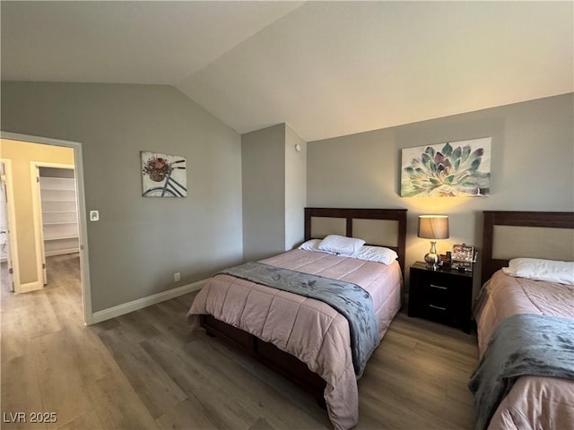 bedroom featuring vaulted ceiling, wood finished floors, and baseboards