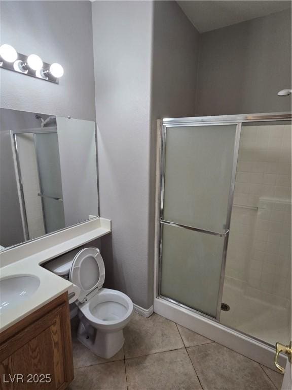 bathroom with tile patterned floors, vanity, toilet, and an enclosed shower