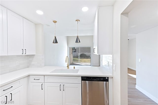 kitchen with stainless steel dishwasher, decorative light fixtures, white cabinets, and sink