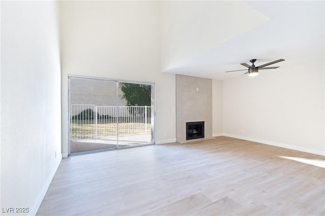 unfurnished living room featuring ceiling fan, light hardwood / wood-style floors, and a fireplace