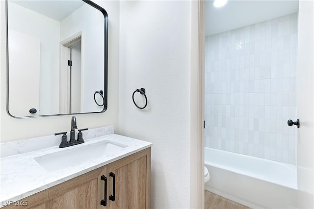 full bathroom featuring washtub / shower combination, vanity, and toilet