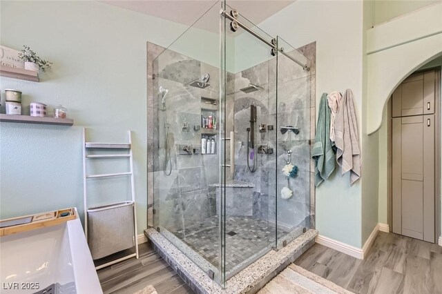 bathroom with hardwood / wood-style flooring and a shower with shower door