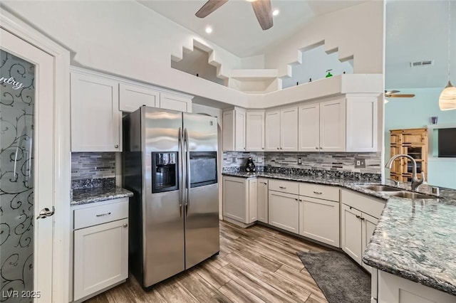 kitchen featuring sink, white cabinets, and stainless steel refrigerator with ice dispenser