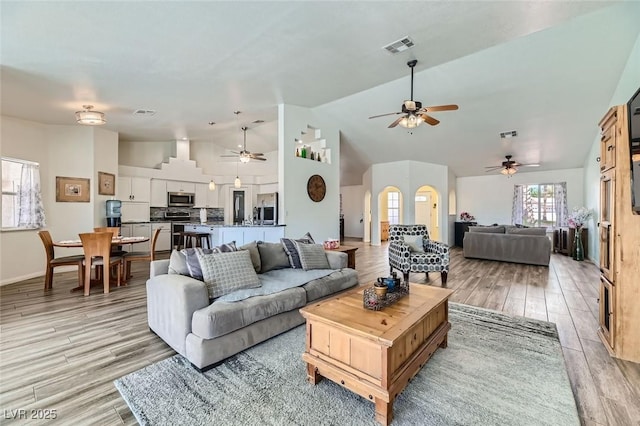 living room featuring light hardwood / wood-style flooring and high vaulted ceiling