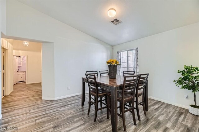 dining space with hardwood / wood-style flooring and lofted ceiling