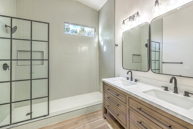 bathroom featuring lofted ceiling, wood-type flooring, walk in shower, and vanity