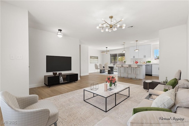 living room with light hardwood / wood-style flooring and a notable chandelier