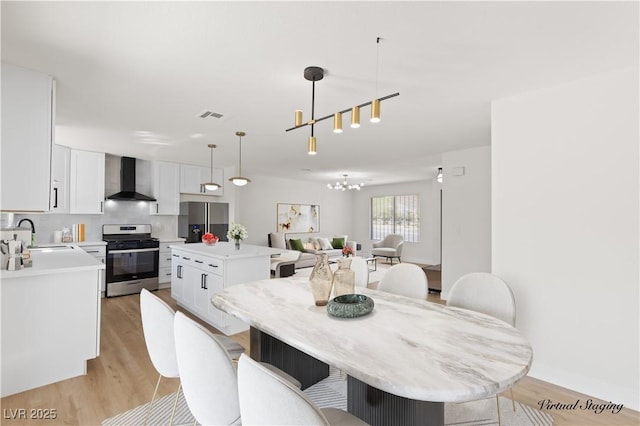 dining space featuring light wood-type flooring and sink