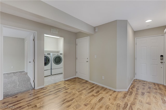 laundry room with washer and dryer and light hardwood / wood-style floors