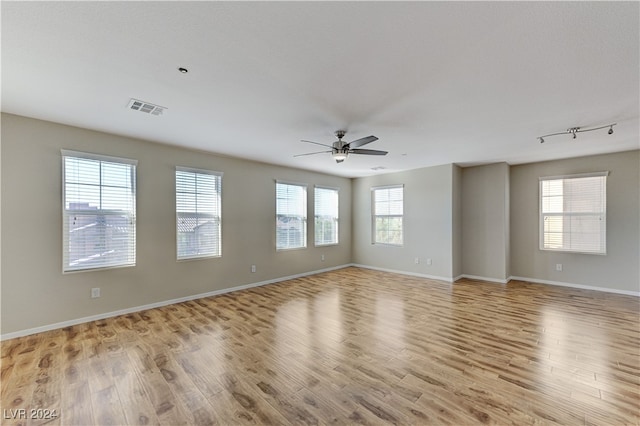 spare room featuring ceiling fan, light hardwood / wood-style floors, and plenty of natural light