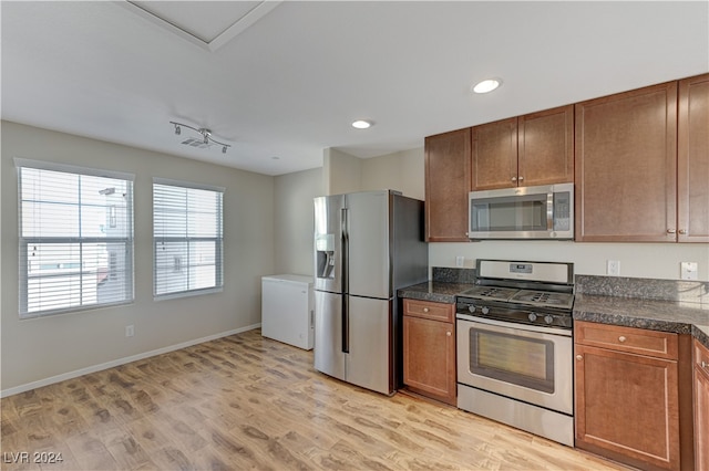 kitchen featuring rail lighting, stainless steel appliances, and light hardwood / wood-style floors