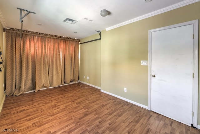 spare room with hardwood / wood-style floors and ornamental molding