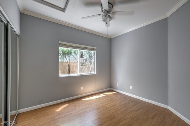 unfurnished bedroom with hardwood / wood-style flooring, ceiling fan, and crown molding