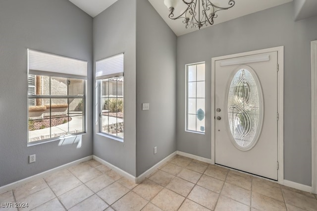 tiled foyer entrance with a chandelier and a healthy amount of sunlight