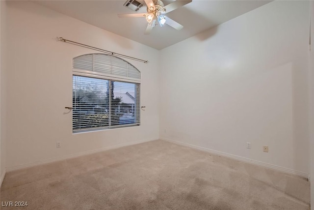 spare room featuring light carpet and ceiling fan