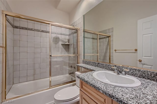 full bathroom featuring shower / bath combination with glass door, vanity, and toilet