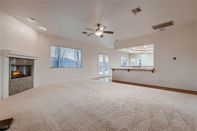 unfurnished living room with carpet flooring and ceiling fan