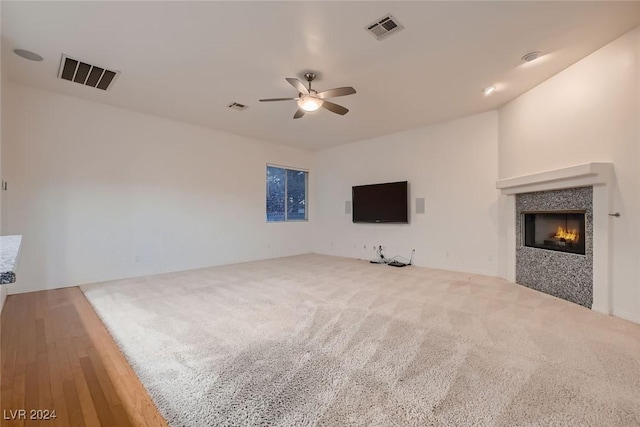 unfurnished living room featuring carpet and ceiling fan