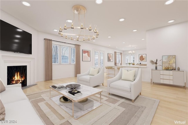 living room with a notable chandelier and light wood-type flooring