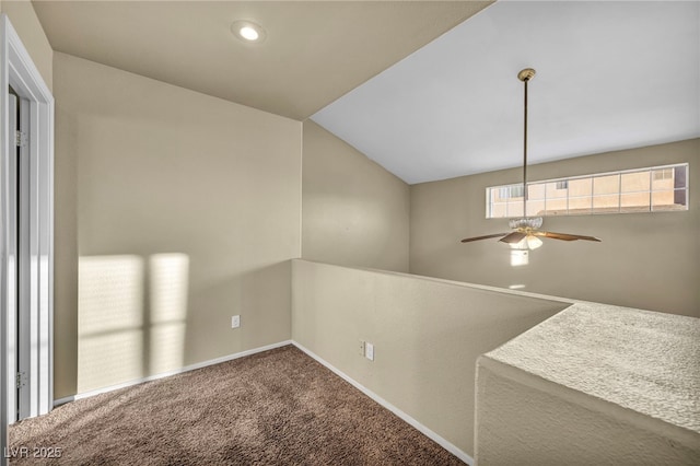 empty room with lofted ceiling, ceiling fan, and carpet