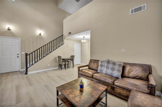 living room with light hardwood / wood-style flooring and a high ceiling