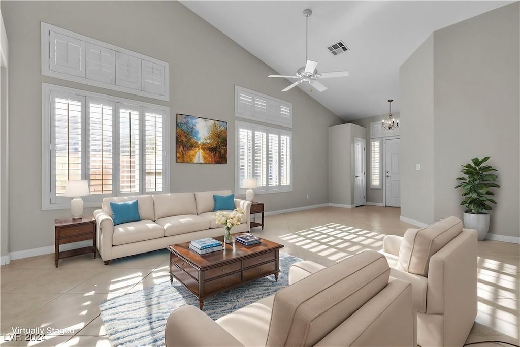 living room with light tile patterned floors, ceiling fan with notable chandelier, and high vaulted ceiling