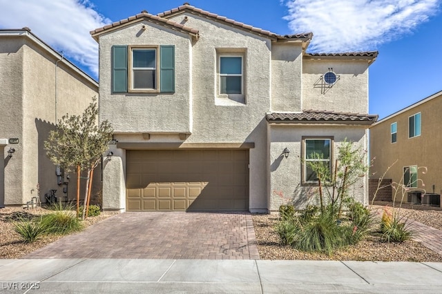 mediterranean / spanish-style home with central AC and a garage