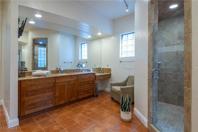 bathroom with tile patterned flooring, vanity, and walk in shower