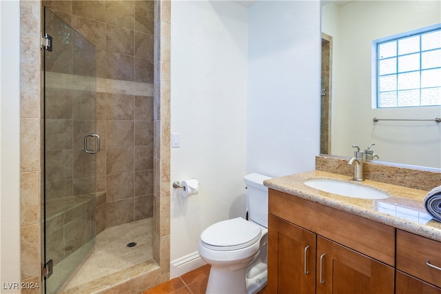 bathroom with tile patterned flooring, vanity, an enclosed shower, and toilet