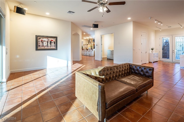 tiled living room featuring ceiling fan and french doors