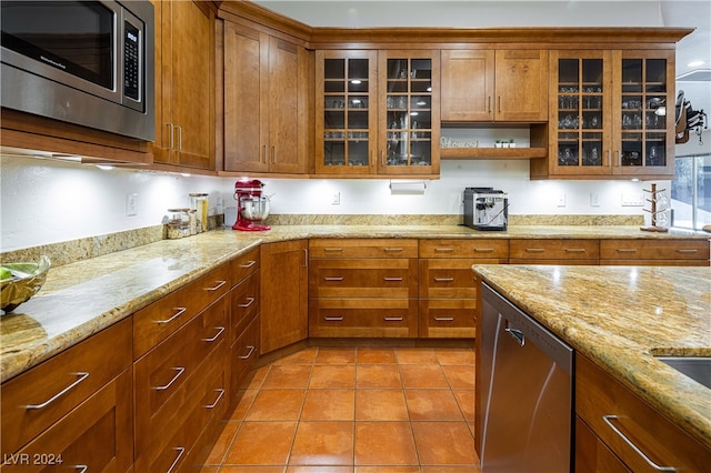 kitchen with light stone counters, light tile patterned floors, and appliances with stainless steel finishes