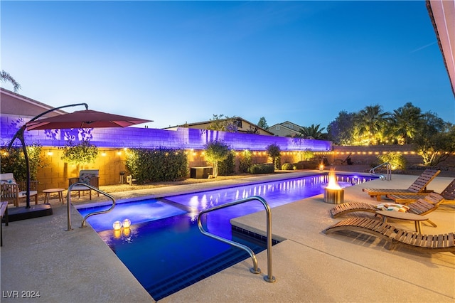 pool at dusk featuring a patio area