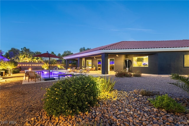 pool at dusk with a patio