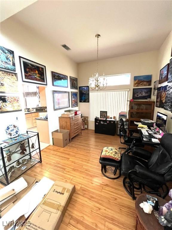 office space with light hardwood / wood-style flooring and a notable chandelier