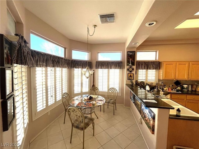 kitchen with plenty of natural light, light tile patterned floors, and hanging light fixtures