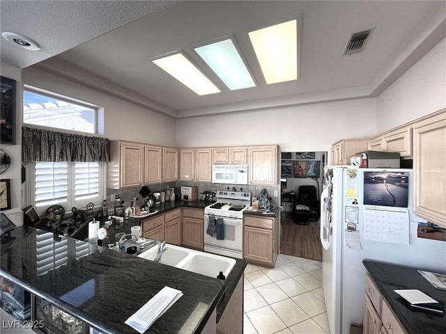 kitchen featuring light brown cabinets, light tile patterned flooring, white appliances, and sink