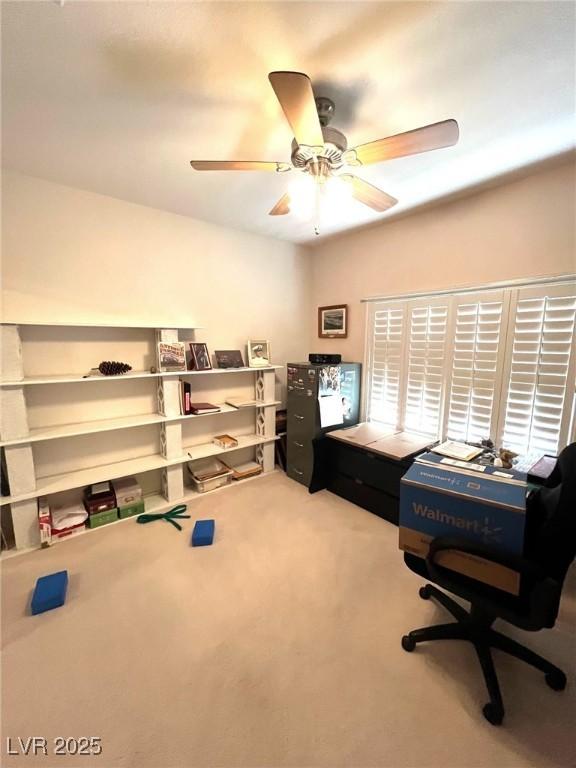 carpeted office space featuring ceiling fan