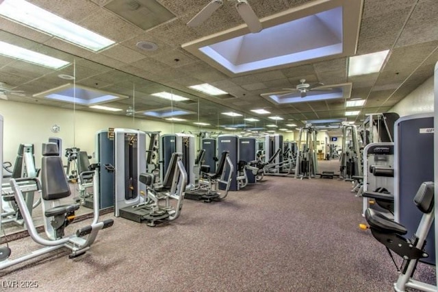 workout area featuring ceiling fan and a drop ceiling