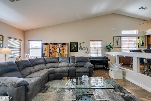 living room with plenty of natural light, ceiling fan, and lofted ceiling