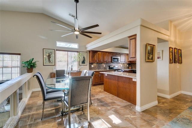 kitchen with backsplash, plenty of natural light, vaulted ceiling, and appliances with stainless steel finishes