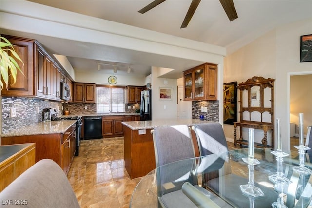 kitchen with tasteful backsplash, light stone counters, and black appliances