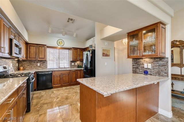 kitchen with kitchen peninsula, light stone countertops, and black appliances